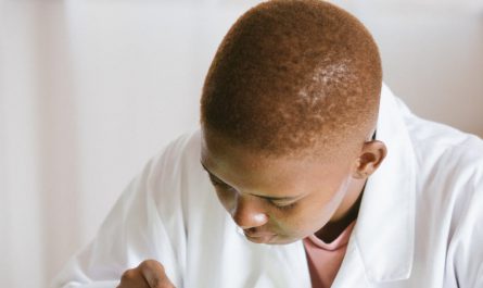 focused african american technical worker replacing faulty elements on video card