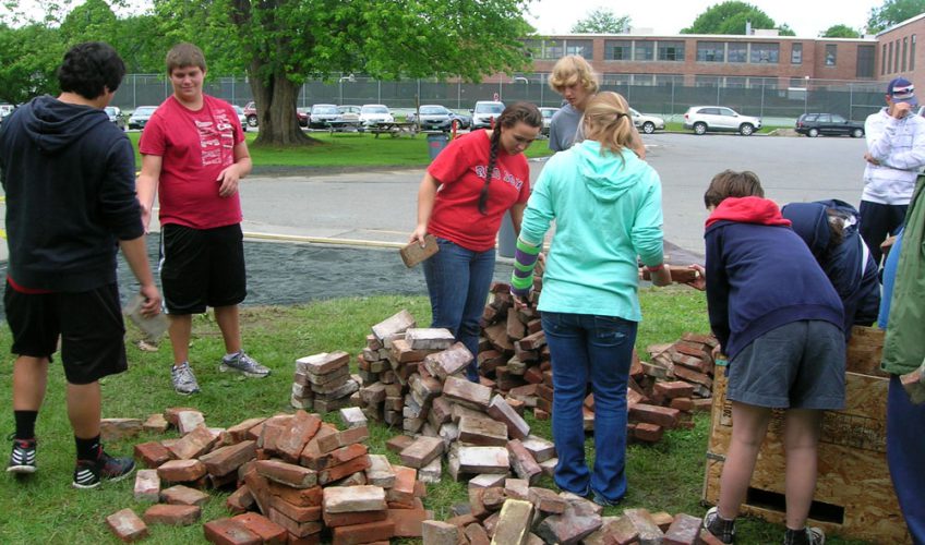 Students and staff prepare a Pompeii style brick.