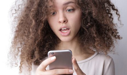 surprised young woman browsing mobile phone