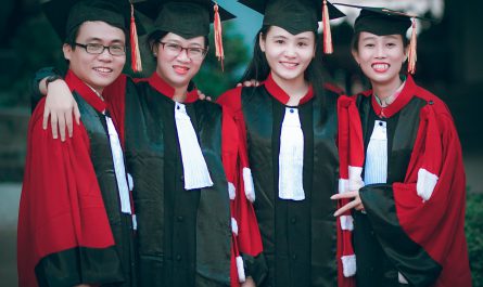 man and women wearing red and black academic gowns and black mortar boards